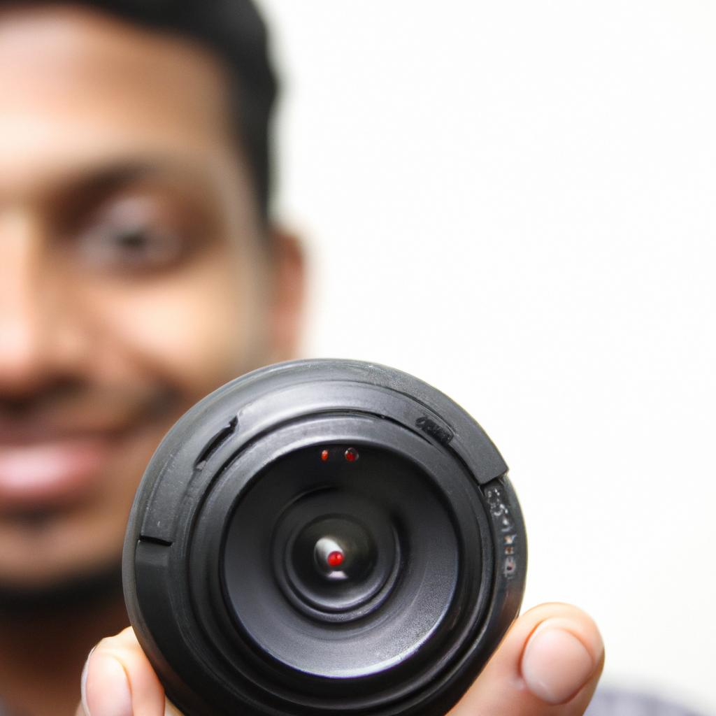 Person holding camera lens, smiling