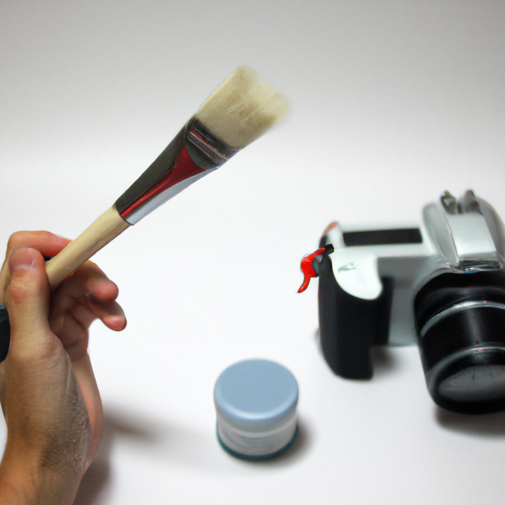 Person holding paintbrush and camera